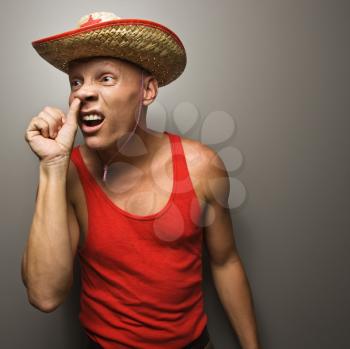 Royalty Free Photo of a Man Wearing a Straw Hat With Thumb to His Nose