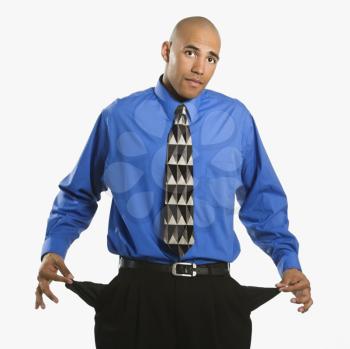 Royalty Free Photo of a Businessman in a Suit Pulling Out Empty Pockets