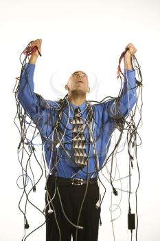 Royalty Free Photo of a Businessman Wrapped in Computer Cables