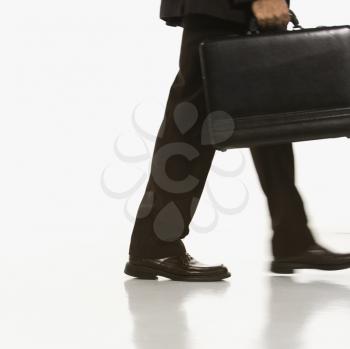 Royalty Free Photo of a Businessman Walking Holding a Briefcase