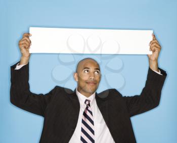 Royalty Free Photo of a Businessman Holding Up a Sign