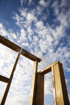 Royalty Free Photo of a Framed Wooden Structure With a Cloudy Blue Sky in the Background