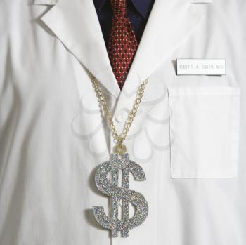 Close up of doctor wearing necklace with over-sized dollar sign.