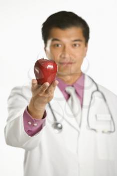 Royalty Free Photo of a Doctor Holding Out an Apple