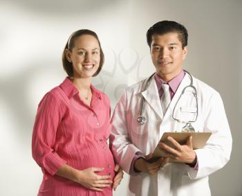 Royalty Free Photo of a Doctor Consulting With His Pregnant Patient
