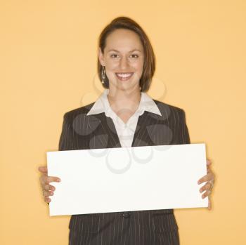 Royalty Free Photo of a Businesswoman Smiling Holding Up a Blank Sign