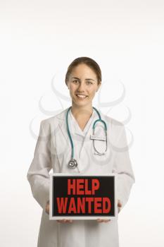 Royalty Free Photo of a Female Doctor Holding Up a Help Wanted Sign