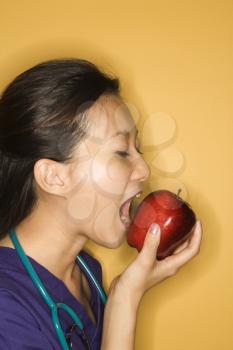 Royalty Free Photo of a Doctor Taking a Bite of an Apple 