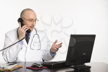 Royalty Free Photo of a Physician Sitting at a Desk With a Computer