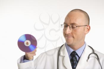 Caucasian mid adult male physician holding compact disc.