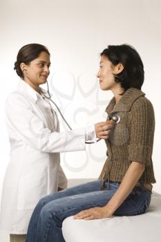 Royalty Free Photo of a Doctor Using a Stethoscope on a Patient