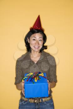 Royalty Free Photo of a Pretty Woman Wearing a Party Hat Holding a Present