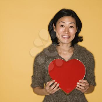 Royalty Free Photo of a Woman Holding a Red Heart Shaped Box