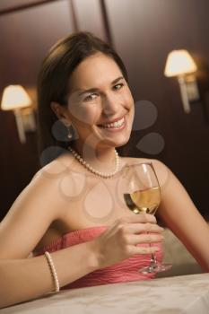 Royalty Free Photo of a Woman Sitting at a Bar With a Glass of White Wine
