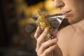 Royalty Free Photo of a Close-up of a Woman Drinking a Martini With Three Olives