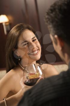 Mid adult Caucasian couple holding wine glasses and smiling.
