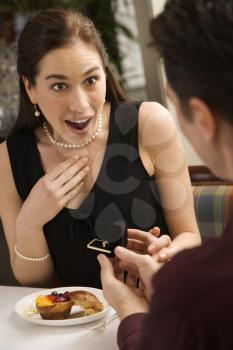 Royalty Free Photo of a Man Proposing to a Woman at a Restaurant