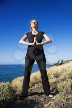 Royalty Free Photo of a Woman Standing on a Hawaiian Coast Practicing Yoga