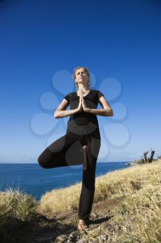Royalty Free Photo of a Woman Standing on Hawaiian Coast in a Yoga Tree Position