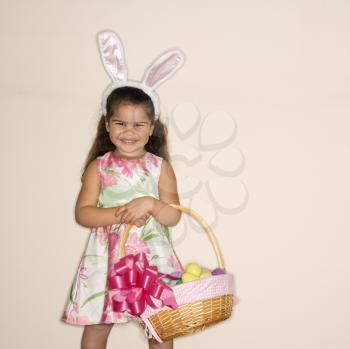 Royalty Free Photo of a Girl Wearing Bunny Ears and Holding an Easter Basket Smiling