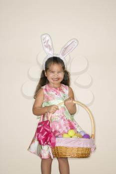 Royalty Free Photo of a Girl Wearing Bunny Ears and Holding an Easter Basket Smiling