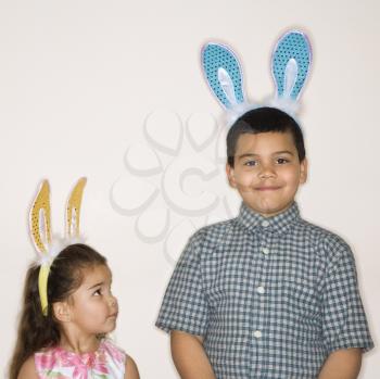 Royalty Free Photo of a Hispanic Boy and Girl Wearing Bunny Ears Smiling 