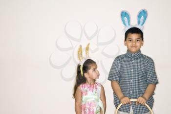 Royalty Free Photo of a Brother and Sister Holding Easter Baskets and Wearing Bunny Ears