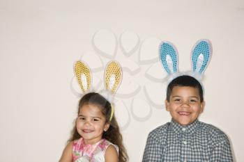 Royalty Free Photo of a Hispanic Boy and Girl Wearing Bunny Ears Smiling 