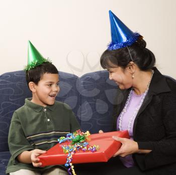 Royalty Free Photo of a Mother Giving a Present to a Surprised Son at a Birthday Party