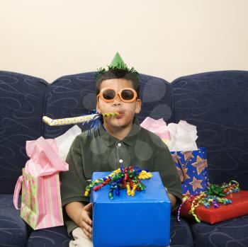 Royalty Free Photo of a Boy With Birthday Party Favors and Presents