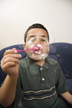 Royalty Free Photo of a Boy Blowing a Large Soap Bubble
