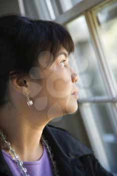 Portrait of Asian Filipino woman gazing out window.