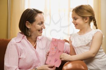Royalty Free Photo of a Girl Giving Her Mother a Drawing