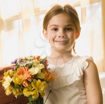 Royalty Free Photo of a Girl Smiling and Holding a Bouquet of Flowers