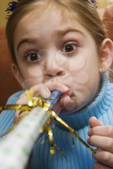 Royalty Free Photo of a Girl Blowing a Noisemaker