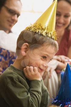 Royalty Free Photo of a Boy Wearing a Party Hat Smiling