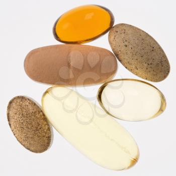 Close up of supplement vitamin pills against white background.