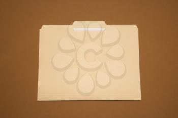 Royalty Free Photo of a Blank Folder on a Brown Background