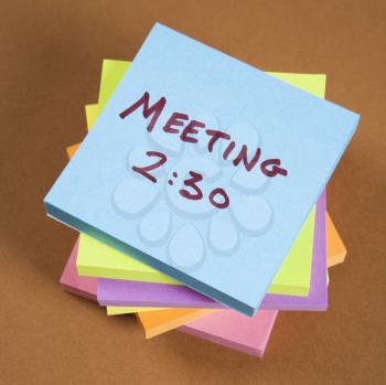 Royalty Free Photo of a Stack of Sticky Notes With a Meeting Reminder