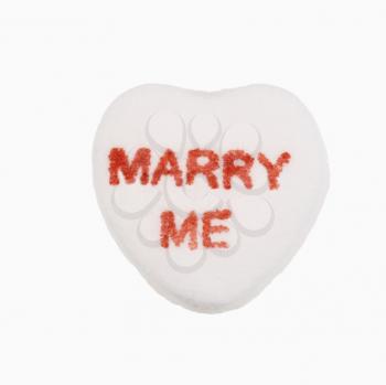 Royalty Free Photo of a White Candy Heart That Reads Marry Me
