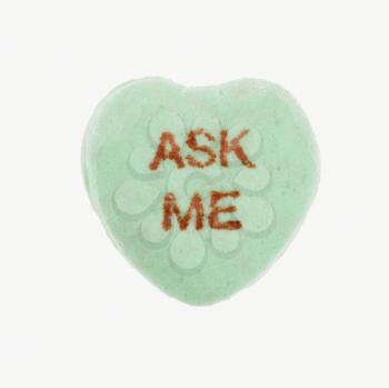 Green candy heart that reads ask me against white background.
