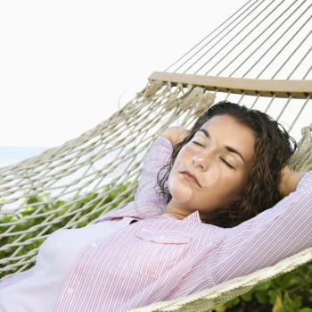 Royalty Free Photo of a Pretty Young Woman Lying in a Hammock With Hands Behind Her Head Sleeping
