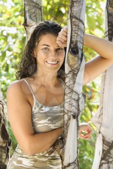 Royalty Free Photo of a Smiling Woman Leaning Against a Tree