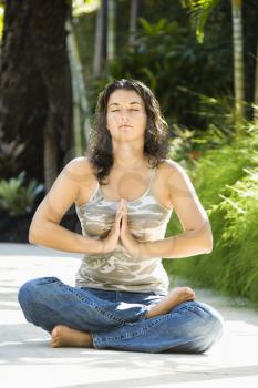 Royalty Free Photo of a Pretty Woman Sitting in a Lotus Position Practicing Yoga With Hands at Heart Center