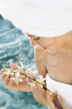 Royalty Free Photo of a Woman Wearing a Towel Around Her Head and Holding Flowers