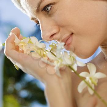 Royalty Free Photo of a Close-up of a Woman Holding White Orchid Flowers Up to Her Face