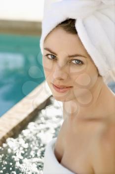 Royalty Free Photo of a Woman a Wearing Robe and Towel Sitting Next to a Pool