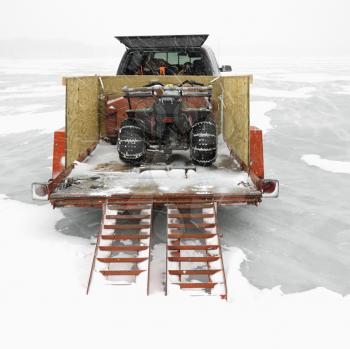 Royalty Free Photo of a Trailer With an ATV Parked on a Frozen Lake in Green Lake, Minnesota, USA