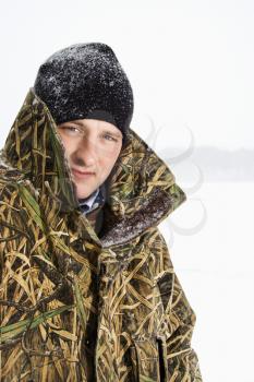 Royalty Free Photo of a Male Wearing a Camouflage Jacket and Beanie on a Frozen Green Lake, Minnesota