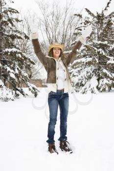 Royalty Free Photo of a Female Standing and Playing in the Snow Wearing a Straw Cowboy Hat